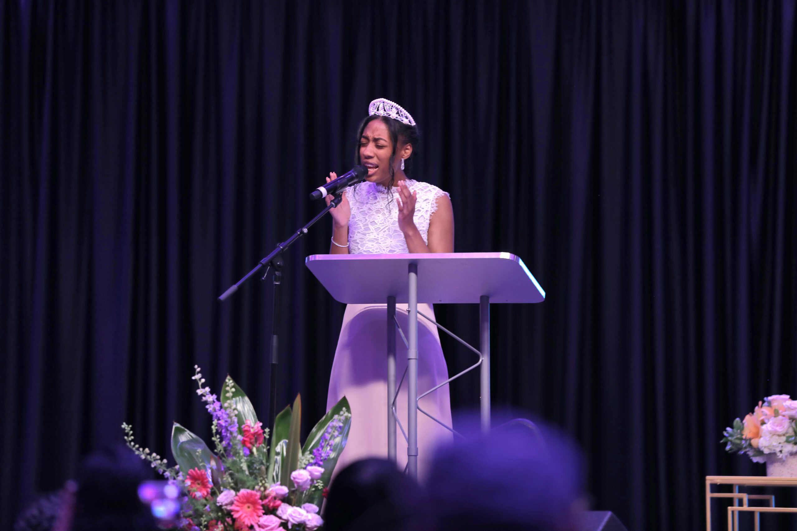 Young woman singing on stage.